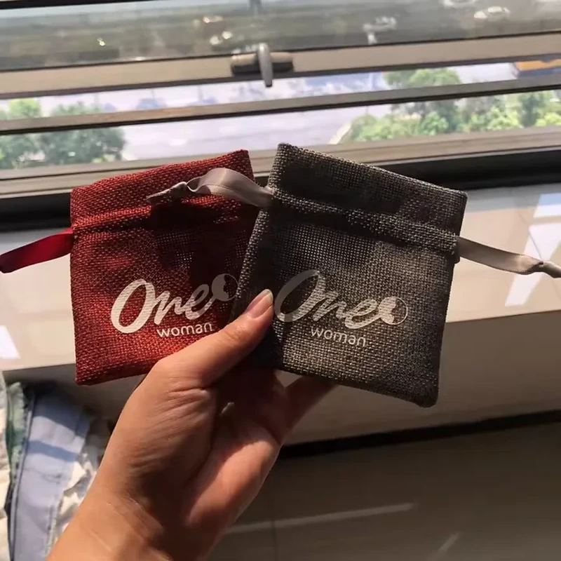 Small red and dark gray woven jewelry pouches with straight ribbon channels and broad printed logos