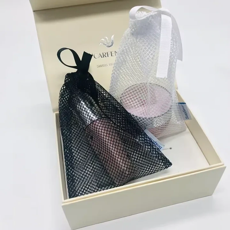 Black and white mesh beauty pouches with ribbon ties beside cosmetic containers