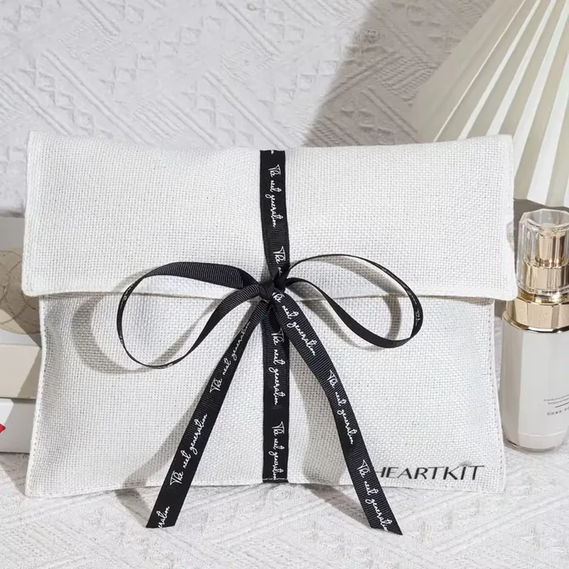 White woven envelope bag tied with a black printed ribbon bow