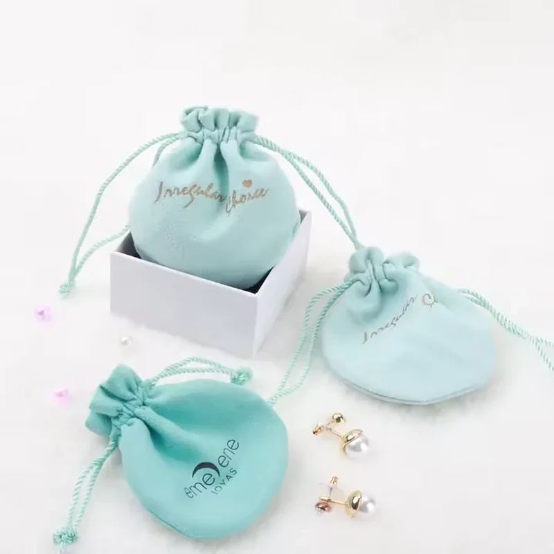 A round silhouette, gathered neck and thin knotted cords define this compact pouch