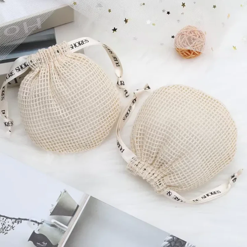 Round cream mesh pouches with printed ribbon drawstrings and curved edges