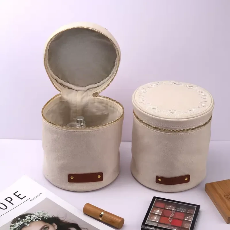 A cylindrical case has a zip around lid, a matching base and a small front label