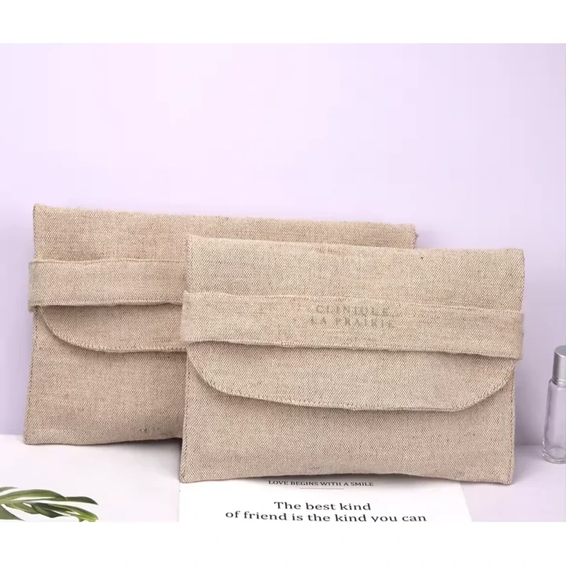 A flat natural tone pouch has a softly rounded flap and a visibly textured surface