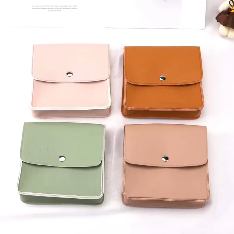 Square leather-look jewelry pouches with rounded flaps and central snaps