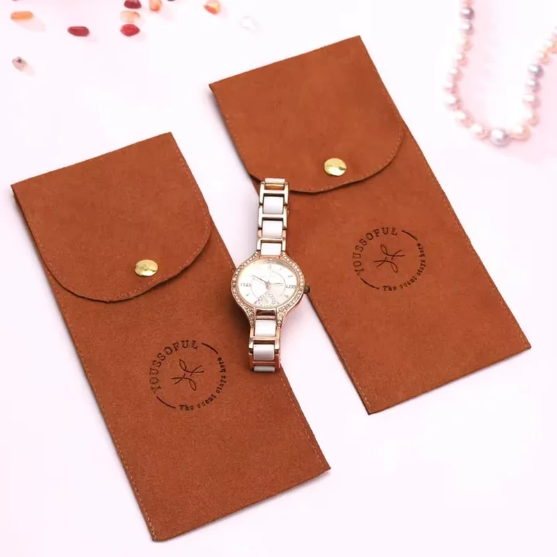A tall narrow jewelry sleeve features a rounded flap with a central metal snap