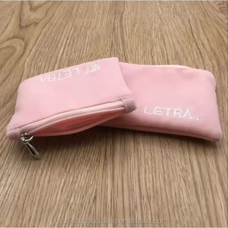 Rounded corners, a zipper and a small wrist loop define this compact accessory pouch