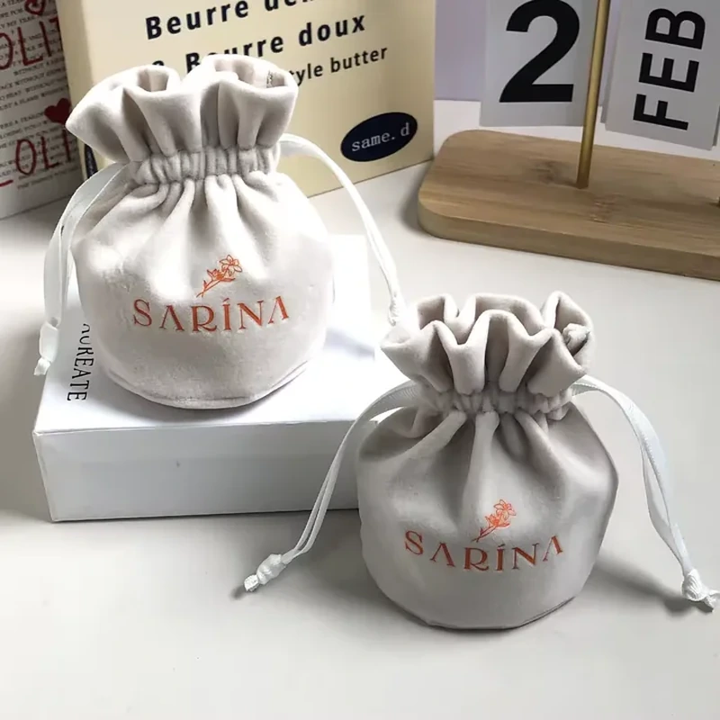 A compact round body narrows into a tall ruffled opening with fine drawstrings