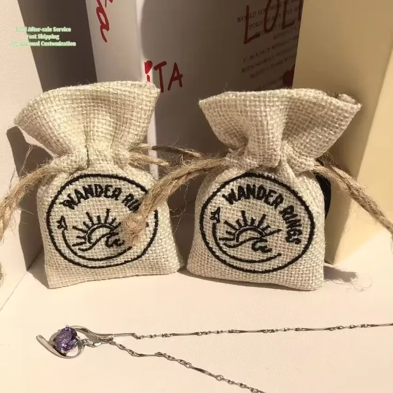 Small burlap-style pouches with high ruffled tops and circular printed emblems