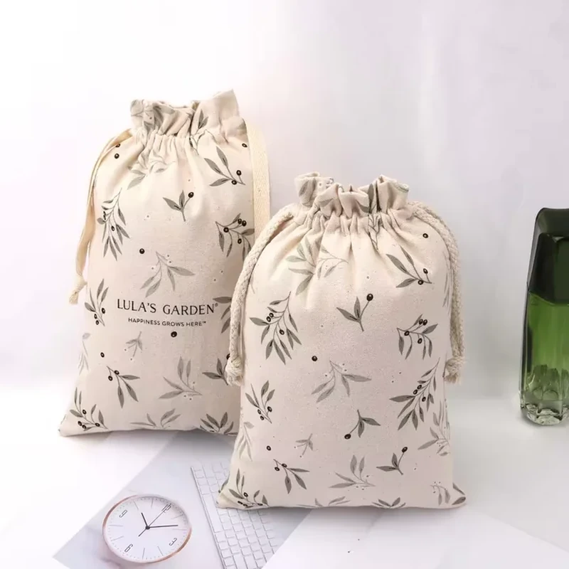 A natural tone pouch is printed with scattered fine botanical sprigs beneath a gathered opening