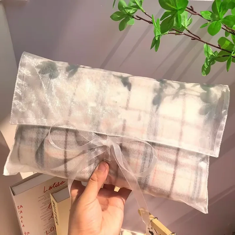 Sheer gift envelope with a broad flap and central translucent ribbon bow