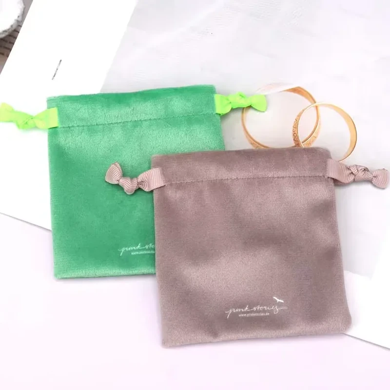 Knotted ribbon ends sit beside a straight top channel on this square pouch