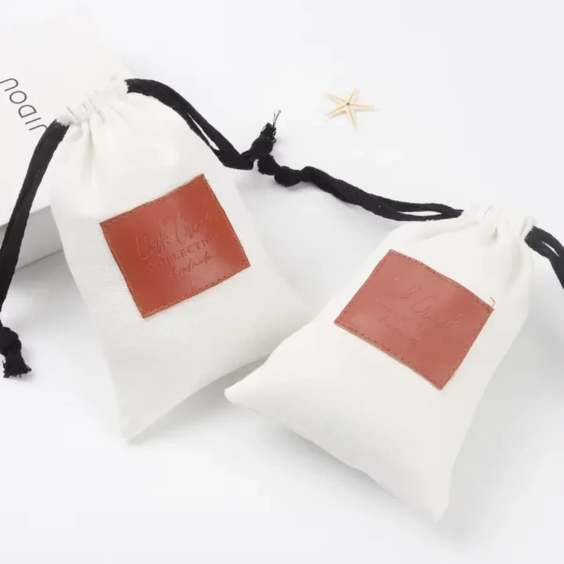 A pale drawstring pouch uses a contrasting square print panel and dark side ribbons