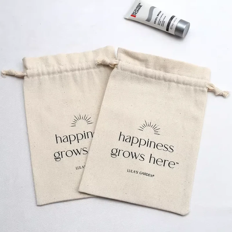 A flat natural tone sleeve features a folded top channel and a small botanical message
