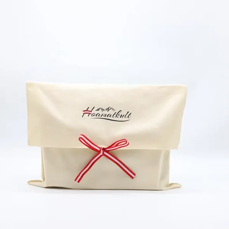 A wide cream pouch combines a foldover flap with a red and white striped bow