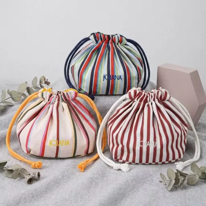 A short rounded pouch has multicolored vertical stripes and a gathered cord opening