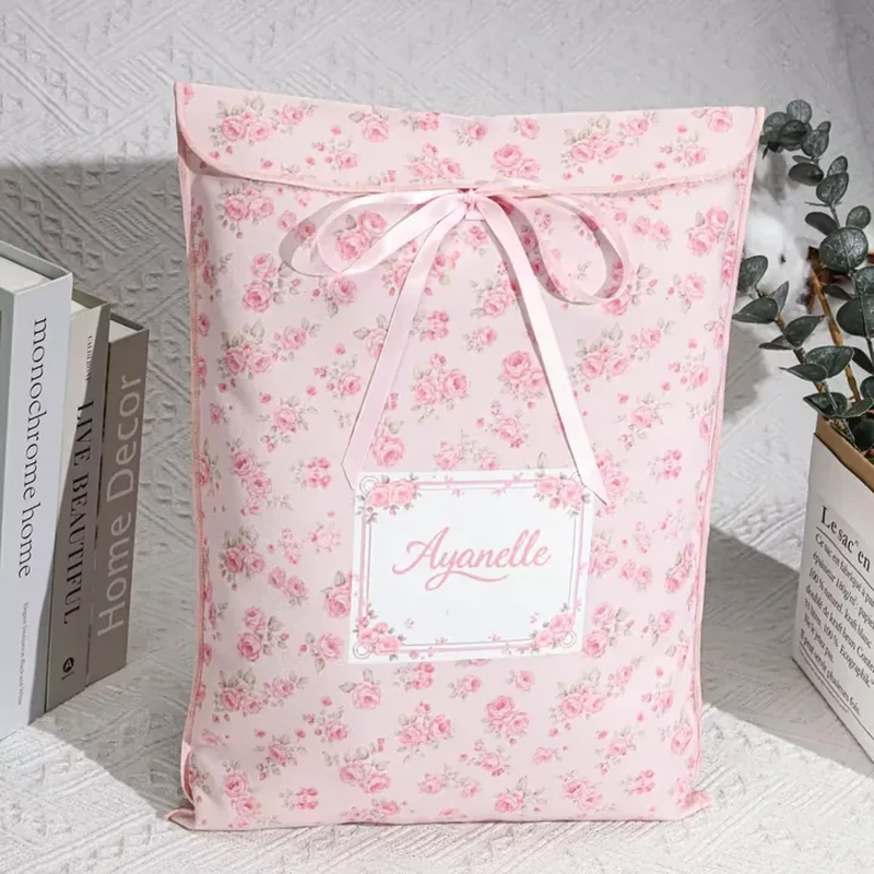 A tall pink floral envelope has a curved upper flap secured with a pale ribbon bow
