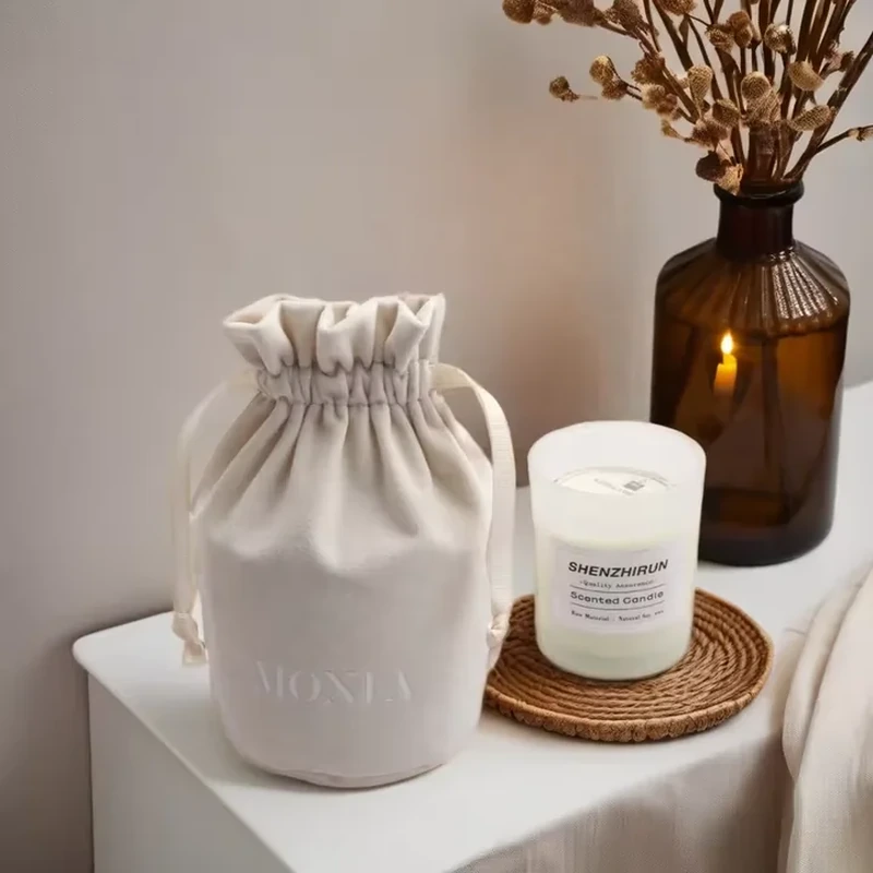 A high ruffled collar sits above a rounded upright pouch shown beside a candle