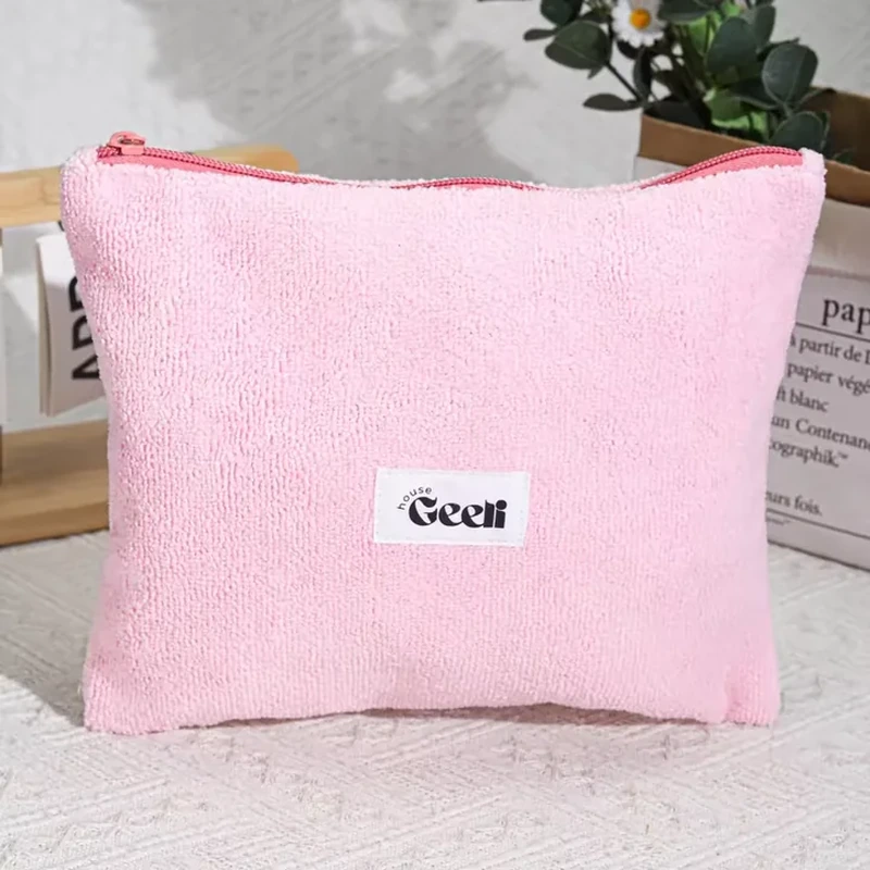Pink flat zipper pouch with clearly looped terry-style fabric and a small sewn front label