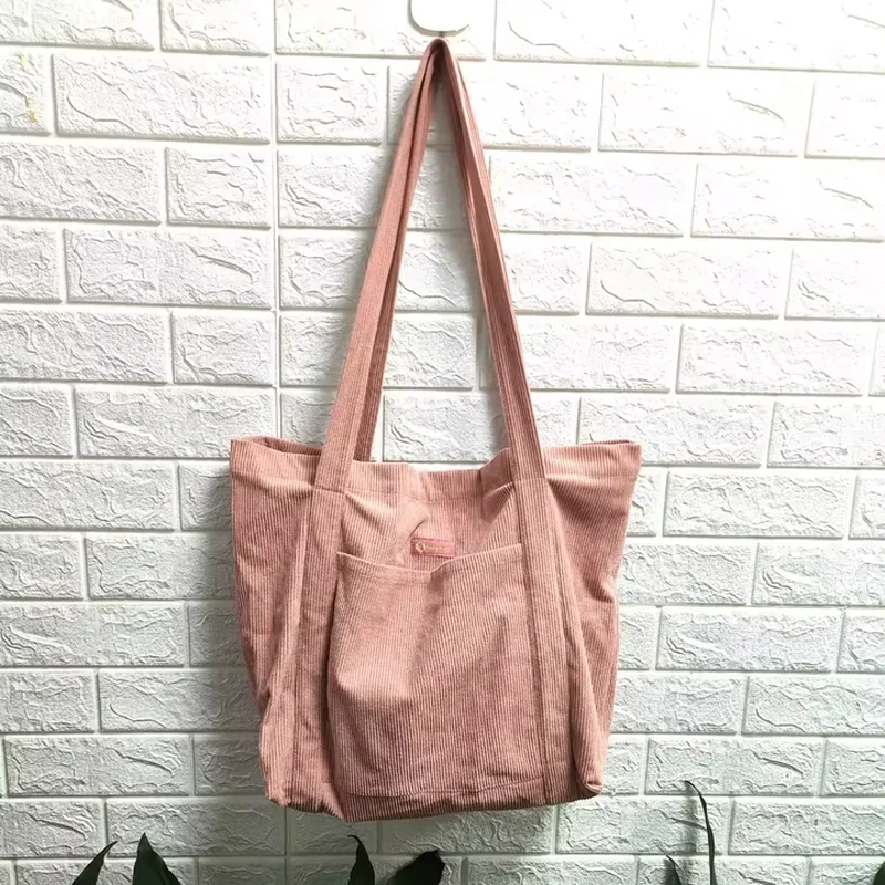Long shoulder straps and textured vertical panels give this tote a distinct surface
