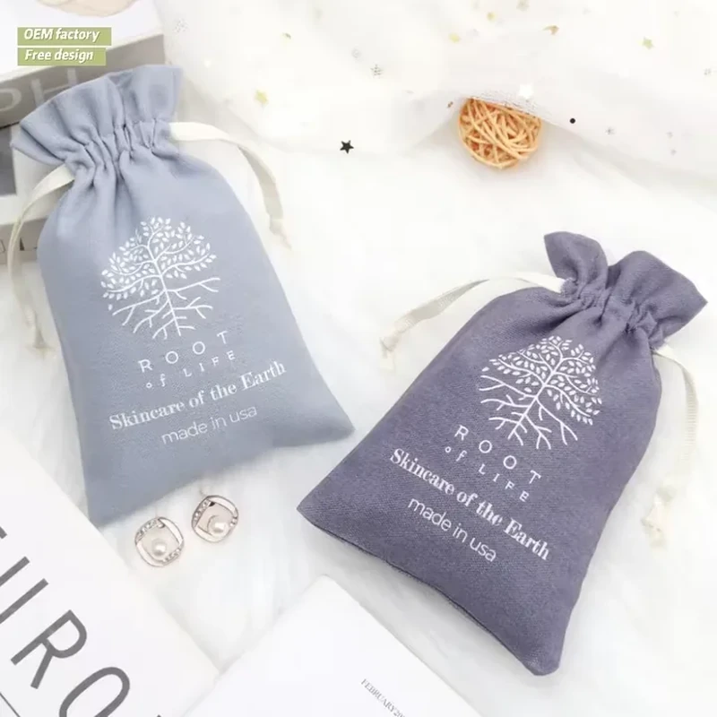 A small pale pouch is printed with a white tree and root illustration beneath its gathered top