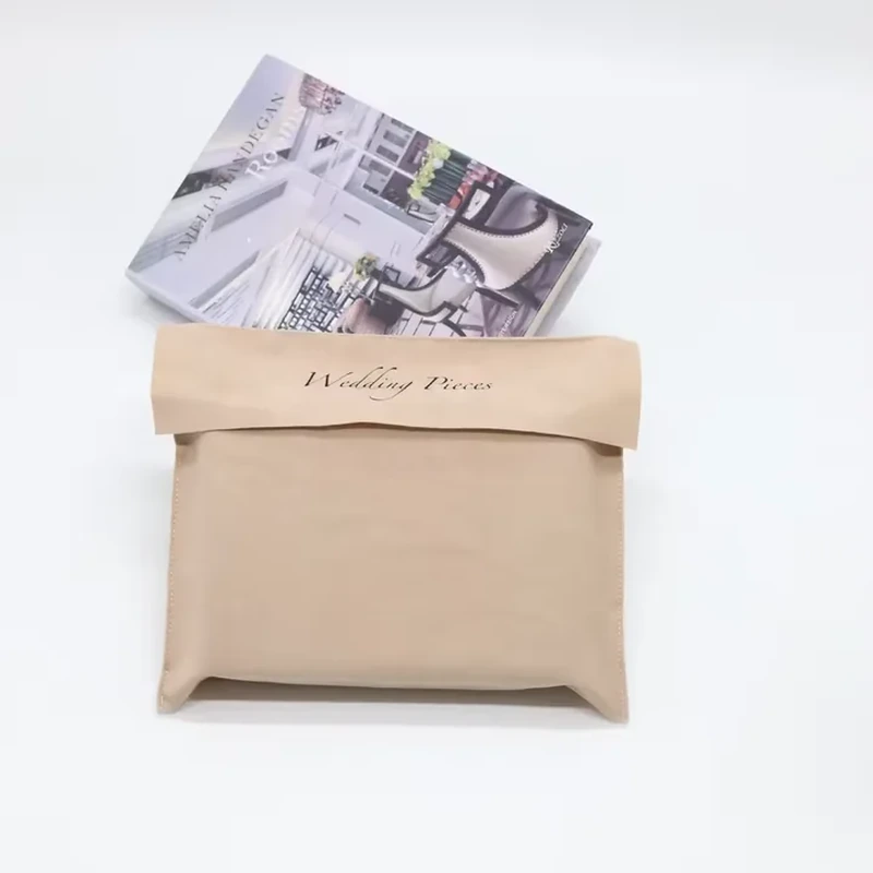 A plain cuff folds across a broad flat pouch with softly boxed corners