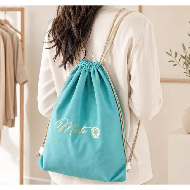 Long shoulder cords gather the top of a flat rectangular backpack-style bag