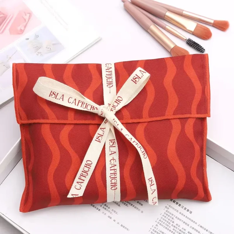 A flat gift envelope has wavy stripes and a contrasting printed ribbon crossing the front