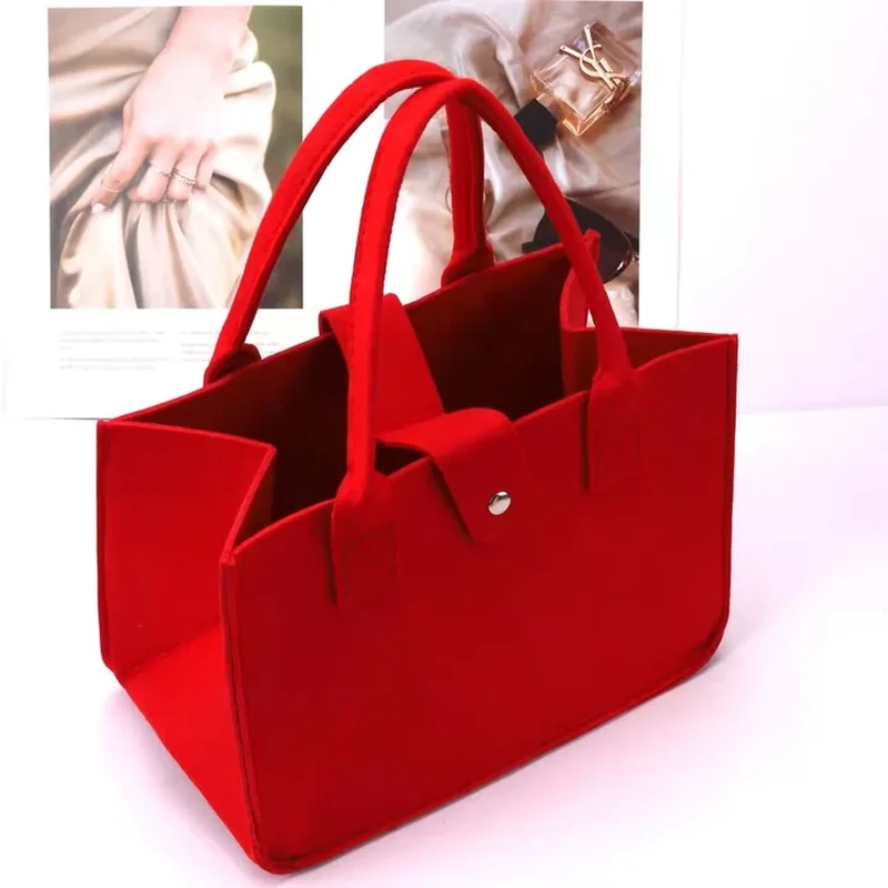 A wide rectangular tote features short rounded handles and small attachment details near the top