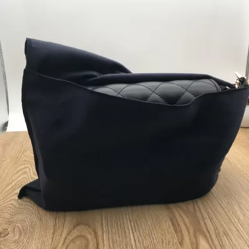A wide zippered cover opens around a handbag, with a broad base and flexible sides