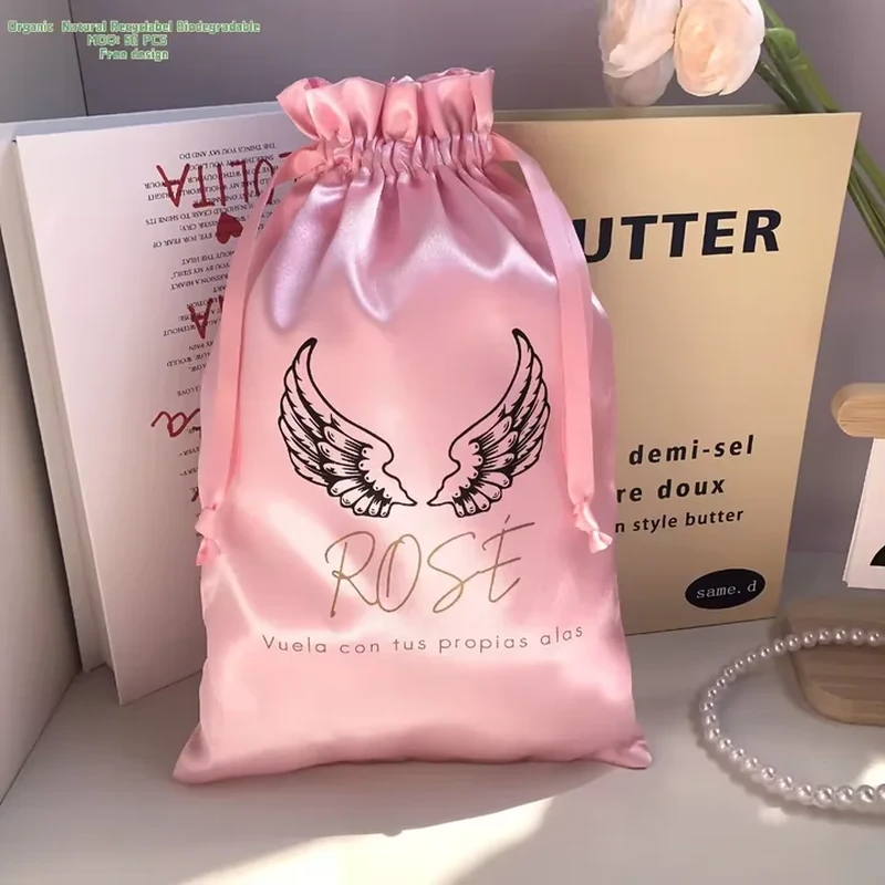 A pair of illustrated wings fills a tall satin pouch beneath its gathered neck