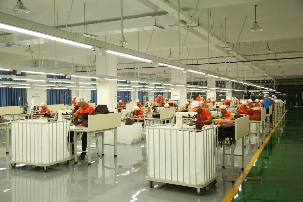 Workers sewing bags at rows of workstations in the factory.