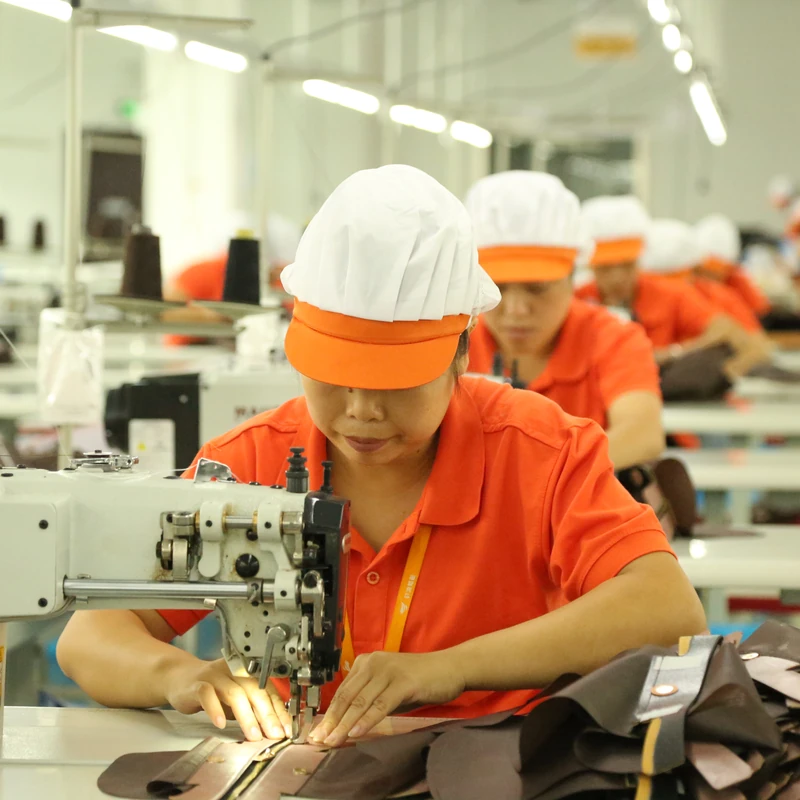 An operator sewing a bag panel at an industrial sewing machine.
