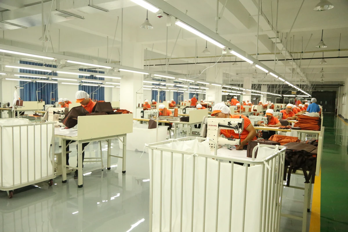 Rows of sewing workstations and operators on the bag production floor.