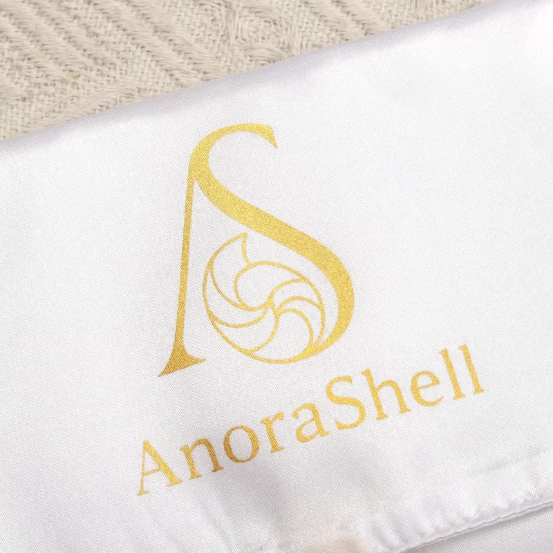 Close-up of a gold-colored mark on light fabric