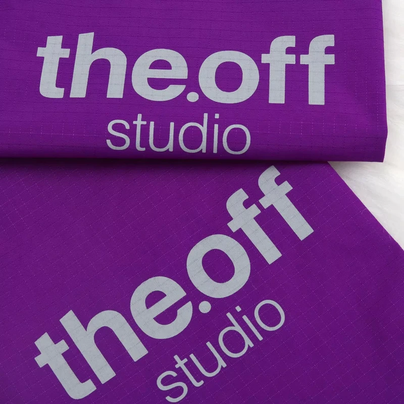 Large pale lettering on purple fabric pouch panels