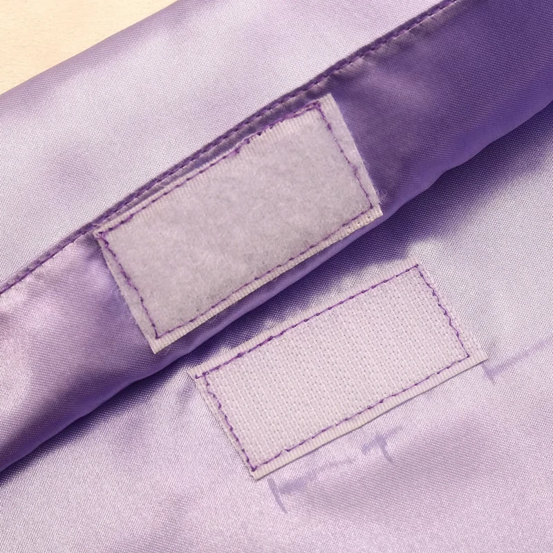 Close-up of hook-and-loop patches stitched onto lilac fabric.