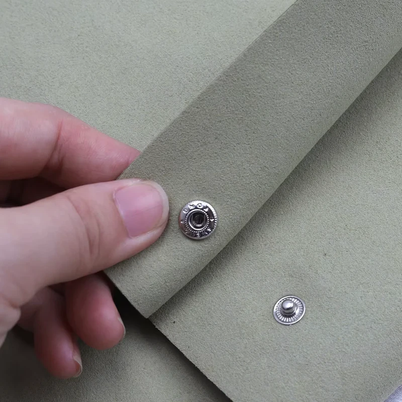Close-up of a snap closure and layered gray fabric
