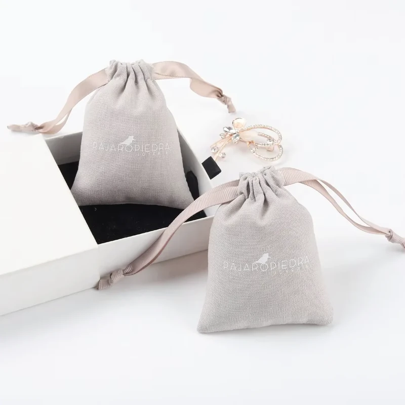 Two small pale drawstring gift pouches in different sizes