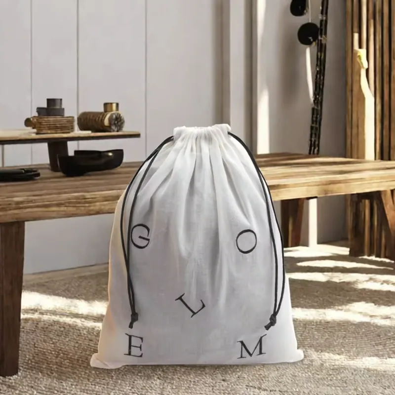 Filled gray drawstring dust bag standing in front of a wooden bench.