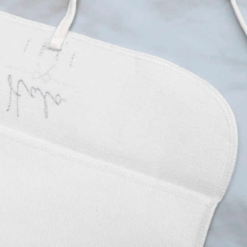 Close-up of the curved inside edge of a cream fabric pouch