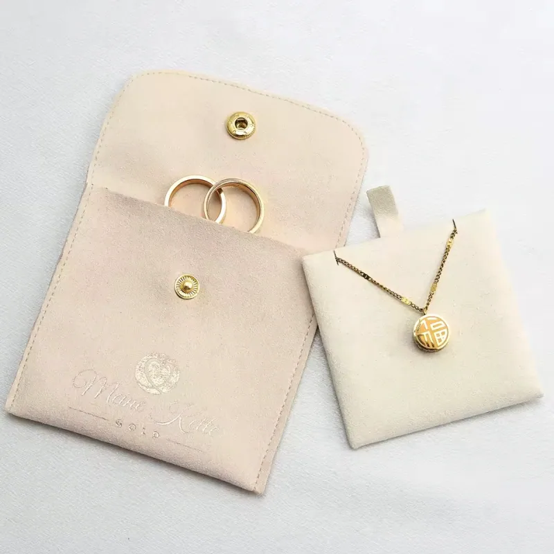 Open beige ring pouch beside a separate necklace display pad