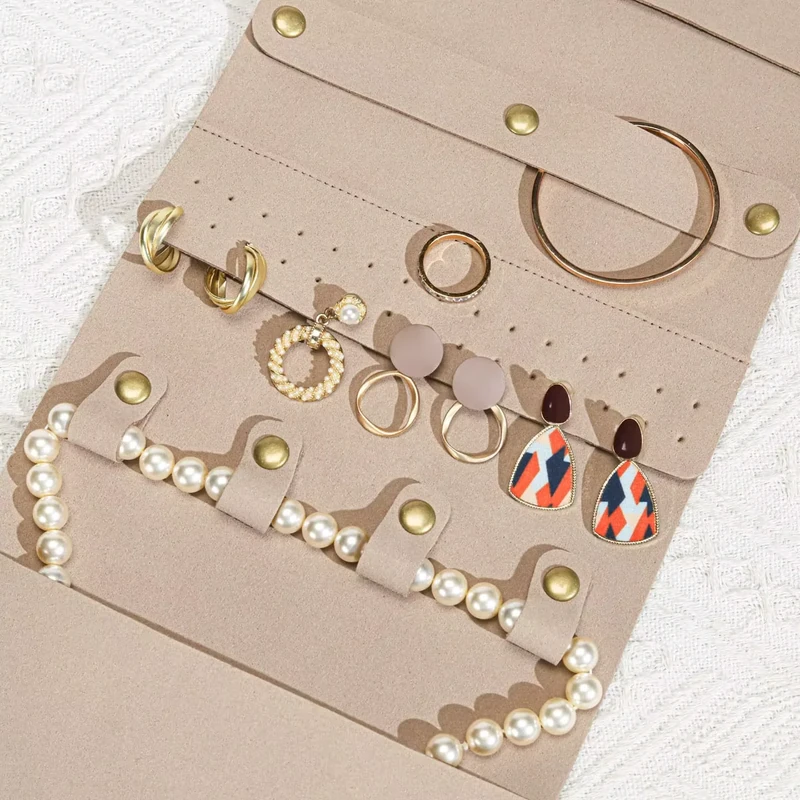 Open jewelry organizer holding rings, earrings and a pearl bracelet.