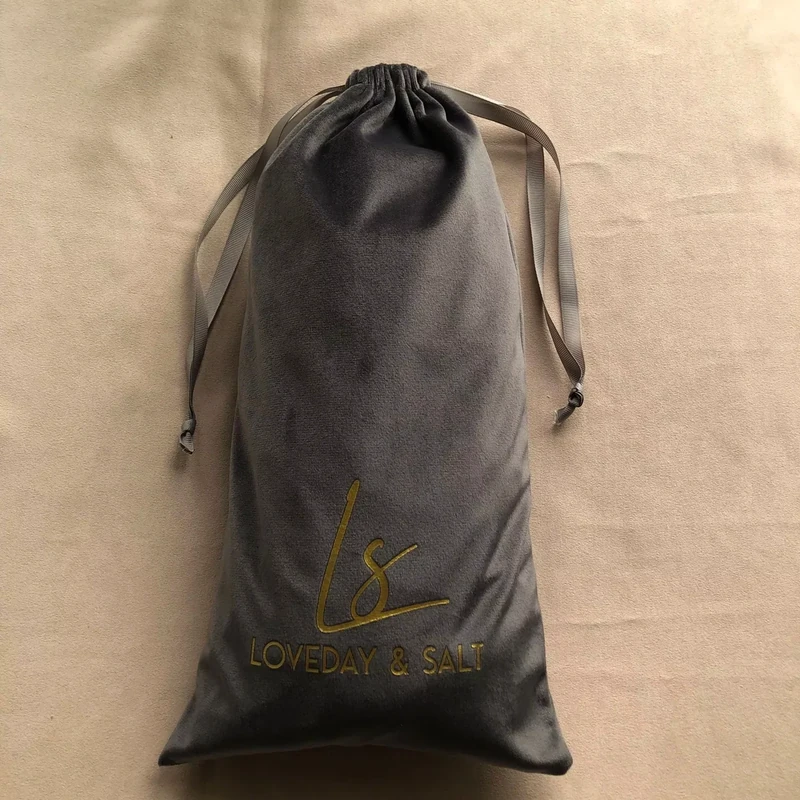 Dark gray drawstring pouch laid on a brown background