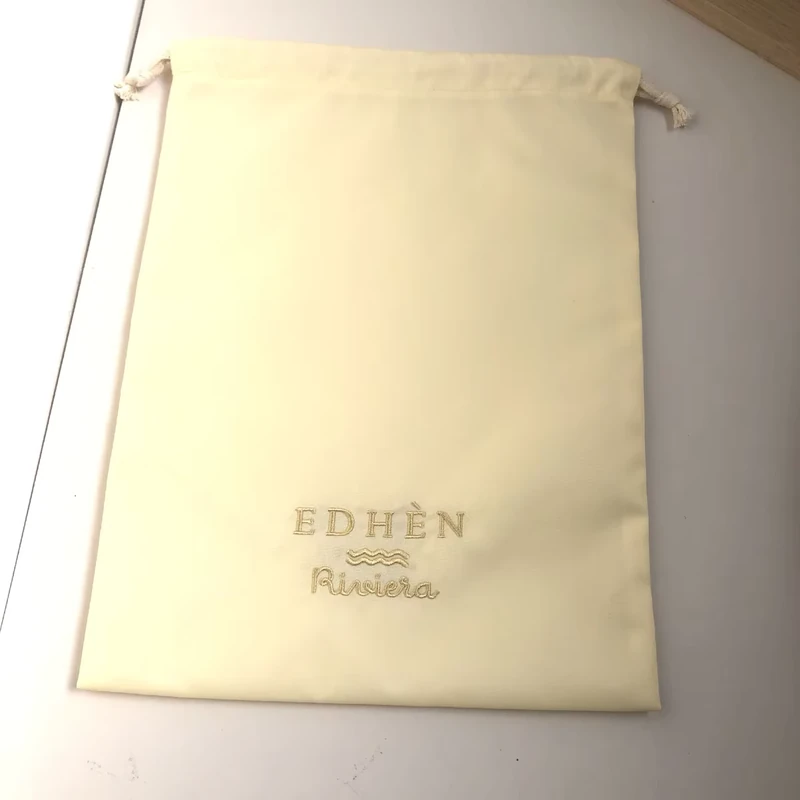 Pale yellow flat drawstring pouch with a small logo