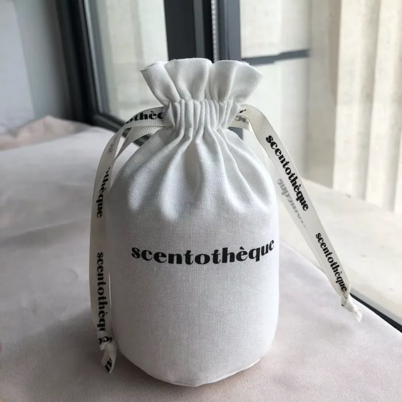 Gathered gray fabric dust pouch with a printed black wordmark.