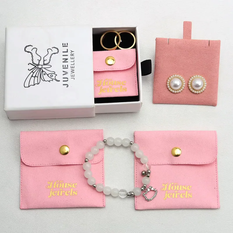 Pink jewelry pouches and display pads with earrings, rings and a pearl bracelet.
