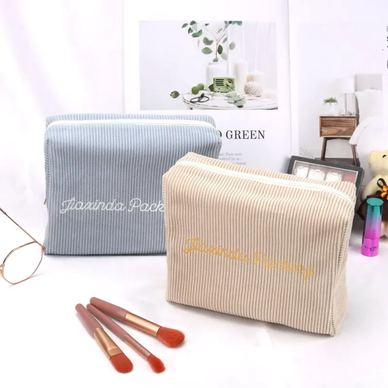 Blue-gray and beige box-shaped zipper pouches arranged in two sizes.