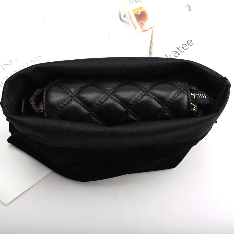 Open black fabric pouch holding a quilted zippered case