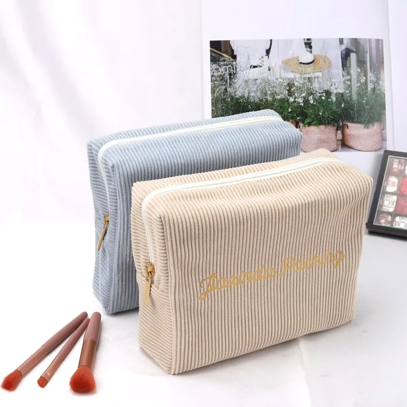Two ribbed zipper pouches in blue-gray and beige.
