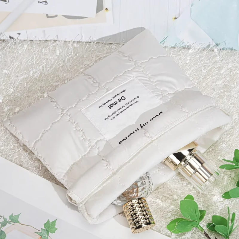 White textured pouch arranged beside cosmetic bottles